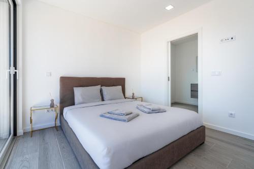 um quarto com uma grande cama branca com duas toalhas em Villa Fifty Shades of Grey em Campelos
