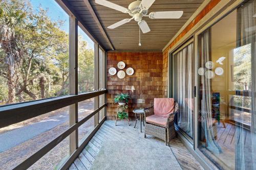 a screened porch with a chair and a ceiling fan at Mariner's Watch 4266 in Kiawah Island