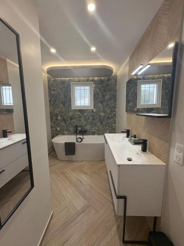 une salle de bain avec deux lavabos et une baignoire dans l'établissement Maison Aiméo en Camargue, à Arles