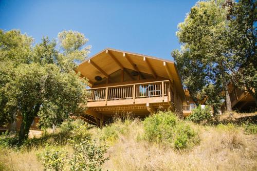a house with a wrap around deck on a hill at Camping Cala Llevado in Tossa de Mar