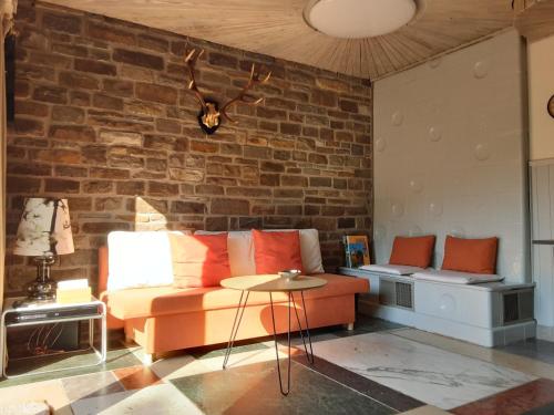 un soggiorno con un divano e un muro di mattoni di Ferienwohnung In Zendscheid Mit Offenem Kamin a Zendscheid