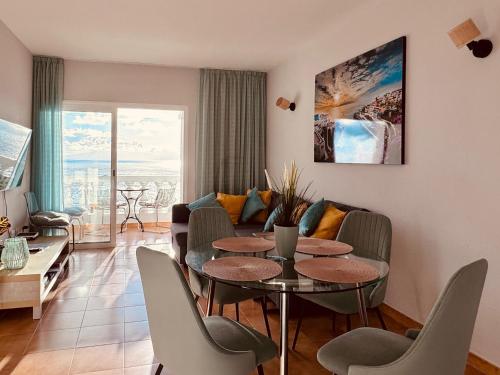 a living room with a table and a couch at Sunset apartment in Puerto de Santiago