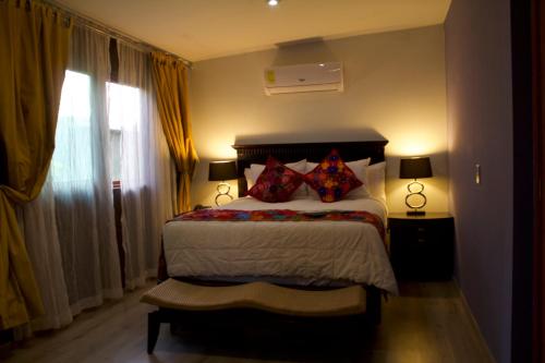 a bedroom with a bed with pillows and a window at Hacienda del Lago Boutique Hotel in Ajijic