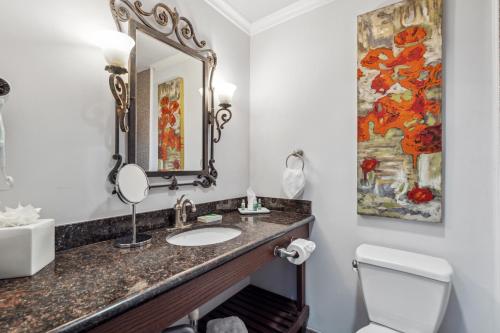 a bathroom with a sink and a mirror at Villa Montes Hotel in San Bruno