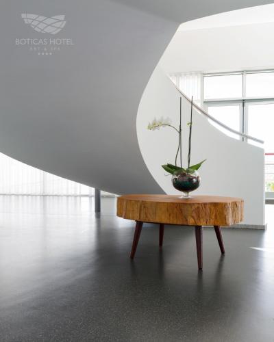 a vase on a wooden table in a white room at Boticas Hotel Art & SPA in Boticas