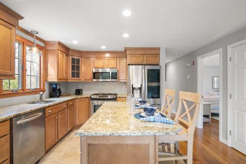 a kitchen with wooden cabinets and a marble counter top at Next to Bike Trail Outdoor Adventure Awaits in Harwich
