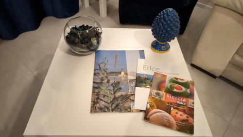 a white table with magazines and a vase on it at Blu Eracleo in Trapani