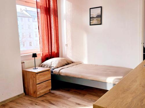 a small bedroom with a bed and a window at Hotel New Town in Dresden