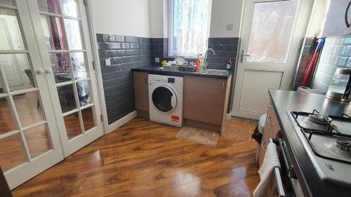 a kitchen with a washing machine and a sink at Harbour House - Entire Detached 4-BDR, Ensuite and Bath, Fast Speed WiFi, Smart TV, Self Catering - Serving Contractors, Tourists, Santa Pod and Silverstone! in Wymington