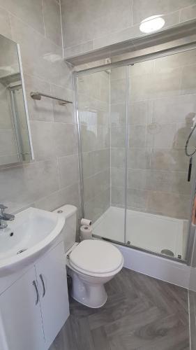 a bathroom with a toilet and a sink and a shower at Harbour House - Entire Detached 4-BDR, Ensuite and Bath, Fast Speed WiFi, Smart TV, Self Catering - Serving Contractors, Tourists, Santa Pod and Silverstone! in Wymington