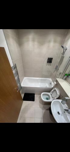 a bathroom with a tub and a toilet and a sink at Room in Central London Zone 1 in London