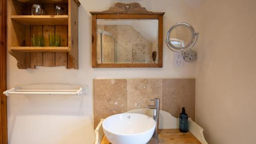 łazienka z umywalką i lustrem w obiekcie Crafty Cottage w mieście Chipping Campden
