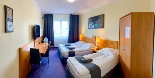 a hotel room with two beds and a desk at LAS SŁUPSKI APARTAMENTY PREMIUM Wifi Netflix Smart TV50 Wysoka Jakość za Niską Cenę Zapraszamy in Słupsk