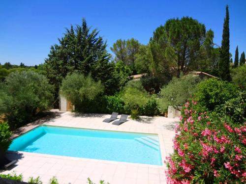 einen Pool in einem Garten mit Blumen in der Unterkunft Les Olives in Uzès