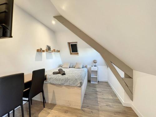 une chambre avec un lit, une table et des chaises dans l'établissement Studio sous les toits Tour d'auvergne, à Saint-Brieuc