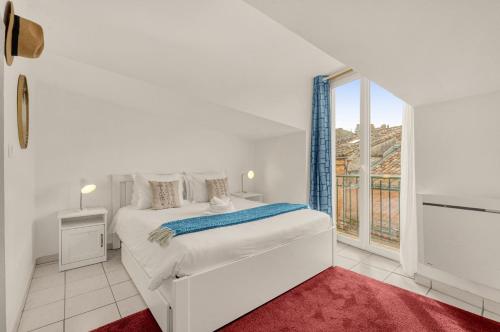 une chambre blanche avec un lit et une grande fenêtre dans l'établissement Bourse des Marchands - 5min de Place du Capitole, à Toulouse