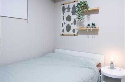 a white bedroom with a white bed and a table at Cozy 2BR Private Basement Suite, Free Parking, WiFi, 1 Hr to Banff, 20 Min to City in Calgary