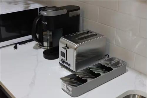 a toaster sitting on a counter next to a coffee maker at Cozy 2BR Private Basement Suite, Free Parking, WiFi, 1 Hr to Banff, 20 Min to City in Calgary
