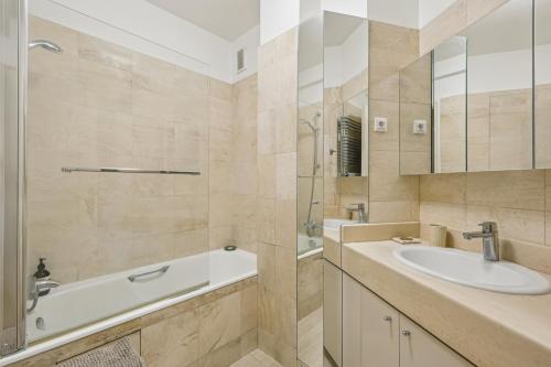 une salle de bain avec un lavabo, un miroir et une baignoire dans l'établissement Nice apartment near Hotel des invalides by Weekome, à Paris