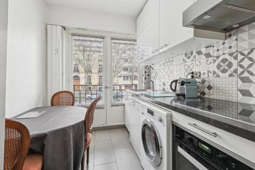 une cuisine avec une table et une machine à laver dans l'établissement Nice apartment near Hotel des invalides by Weekome, à Paris