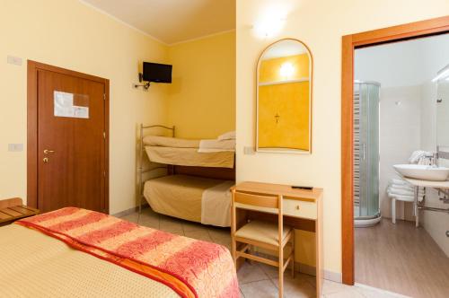 a small room with a bed and a sink at Hotel De La Ville in Rimini