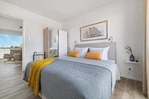 a bedroom with a large bed with two orange pillows at BeachTerraceThree- EG, barrierearm, Meerblick, Terrasse, Kamin, Sauna in Olpenitz