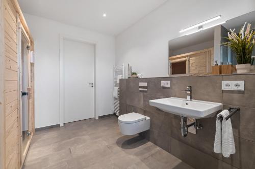 a bathroom with a white sink and a toilet at BeachTerraceThree- EG, barrierearm, Meerblick, Terrasse, Kamin, Sauna in Olpenitz