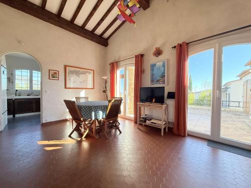 un salon avec une table, des chaises et une télévision dans l'établissement Maison Vue mer- Parking, au Lavandou