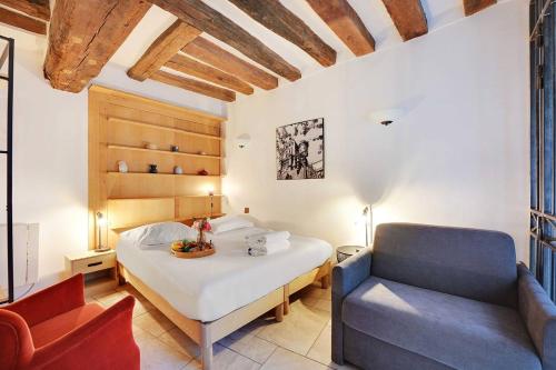 une chambre avec un lit et une chaise dans l'établissement Appartement Maître Albert, à Paris