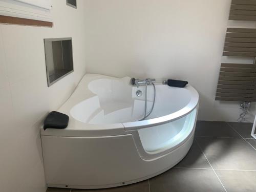 - une baignoire blanche dans une chambre avec un escalier dans l'établissement Warm house with pool and HOT TUB, à Villeveyrac