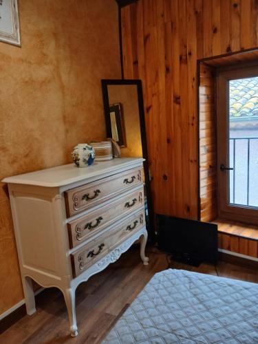 - une commode dans une pièce avec un miroir et une fenêtre dans l'établissement Maison de village, à Vias