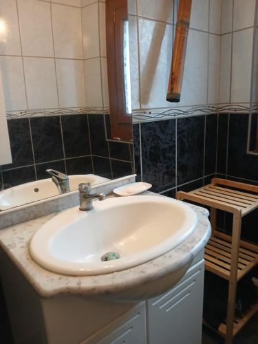 une salle de bain avec un lavabo et une baignoire dans l'établissement Maison de village, à Vias