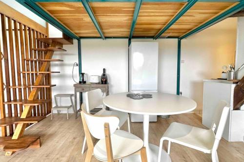 une salle à manger avec une table et des chaises blanches dans l'établissement Esprit LOFT, à Caluire-et-Cuire