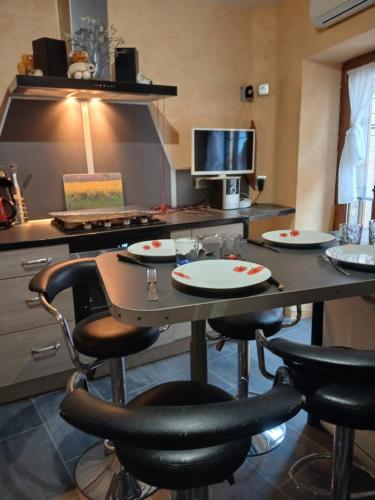 une cuisine avec une table et des chaises avec des assiettes. dans l'établissement Maison de village, à Vias