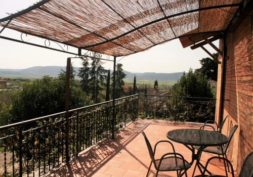 a patio with a table and chairs on a balcony at Podere Olmo Adriano in Sovicille