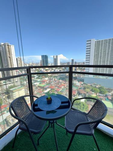 a table and two chairs on a balcony with a view at Bayfront 1BR Condo in Pasay Manila with Wi-Fi, Netflix & Pool Access, Near NAIA Airport, Mall of Asia, OKADA, CCP & PICC in Manila