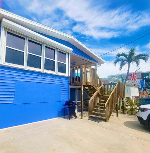 a blue house with a staircase in front of it at DOWNTOWN 3rd Street Retreat Lookout in Fort Myers Beach
