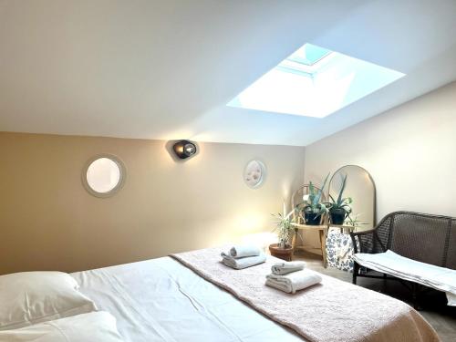 - une chambre avec un lit doté d'une lucarne et de serviettes dans l'établissement Grand duplex plein coeur Vauban, à Marseille