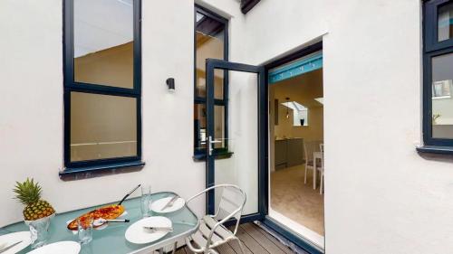 ein Glastisch und Stühle auf einer Terrasse in der Unterkunft Goviers Cottage in Sidmouth