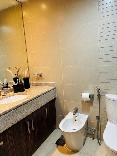 a bathroom with a toilet and a sink and a mirror at ZenStay - Cozy Studio with City Views in Dubai