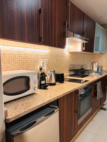 a kitchen with a microwave on a counter at ZenStay - Cozy Studio with City Views in Dubai