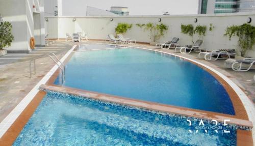 a large swimming pool with chairs in a building at ZenStay - Cozy Studio with City Views in Dubai