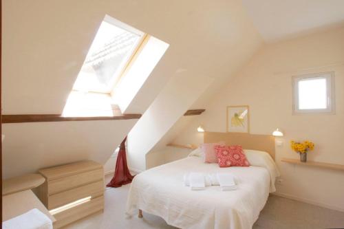 a attic bedroom with a bed and a window at Hotel Des Arts in Puybrun