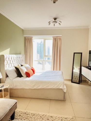 a bedroom with a bed and a large window at ZenStay - Cozy Studio with City Views in Dubai