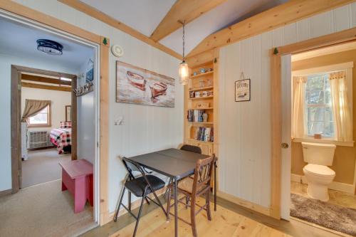ein Esszimmer mit einem Tisch in einem Zimmer in der Unterkunft Palmyra Cottage with Deck on Whites Pond! in Coburn