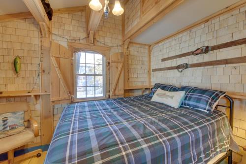 ein Schlafzimmer mit einem Bett in einer Blockhütte in der Unterkunft Palmyra Cottage with Deck on Whites Pond! in Coburn
