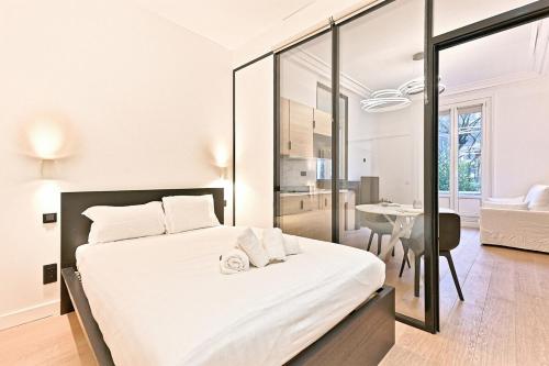 une chambre avec un grand lit blanc et une table dans l'établissement Élégance et Confort Quartier Prestigieux de Paris, à Paris
