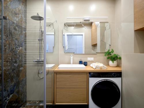 Un baño con lavabo y lavadora. en Prestige Luxury Apartament, en Koszalin