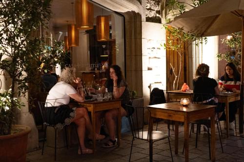 a group of people sitting at tables in a restaurant at Espectacular Depto en Lastarria in Santiago