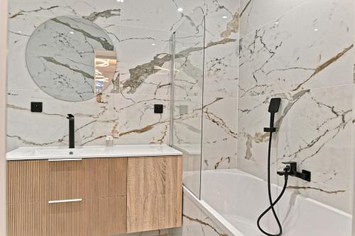 une salle de bain avec une douche, un lavabo et une baignoire dans l'établissement Élégance et Confort Quartier Prestigieux de Paris, à Paris